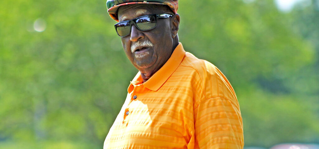 A man in an orange shirt and hat.