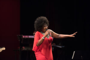 A woman in red is singing on stage